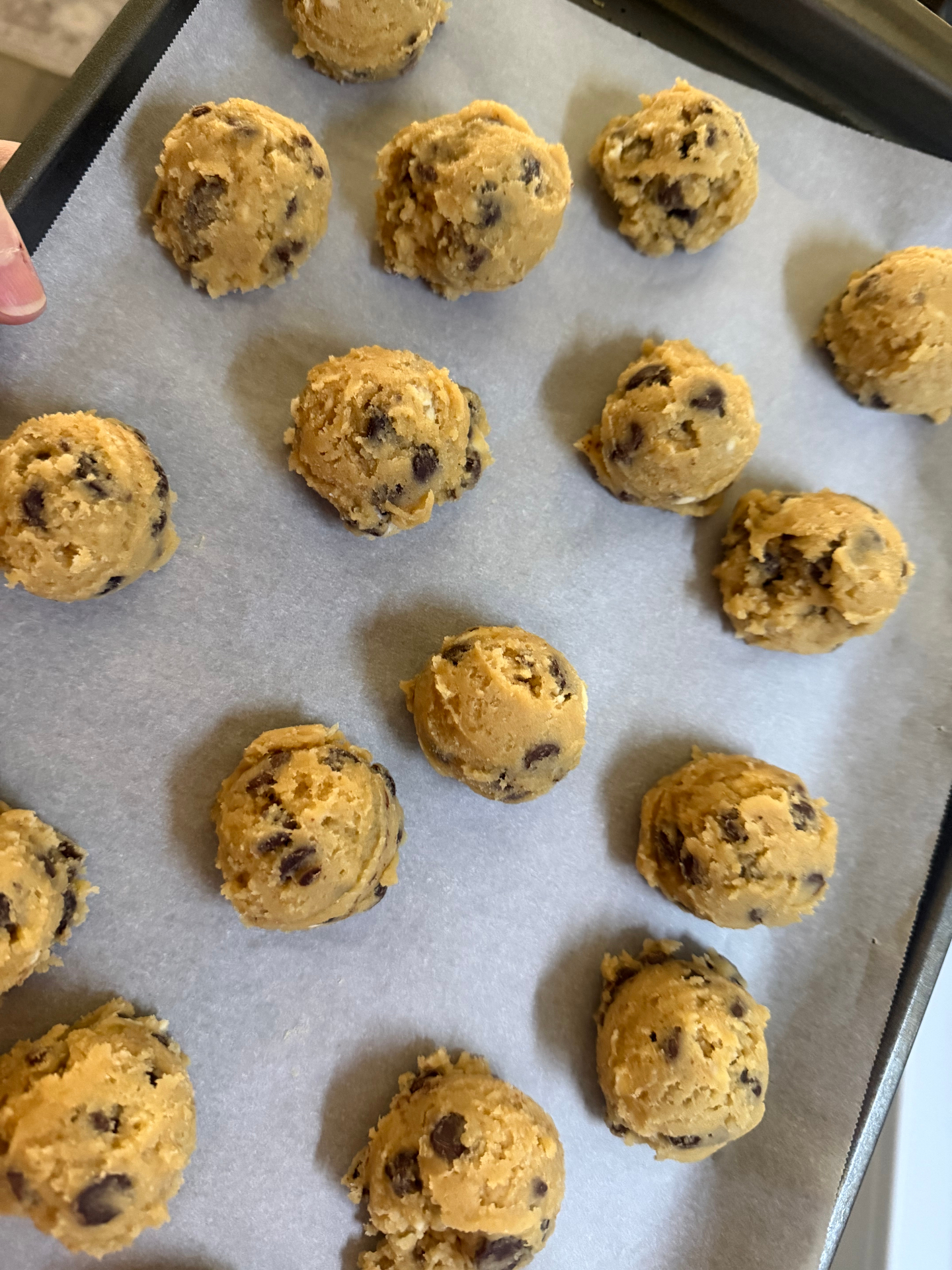 Scooped sourdough chocolate chip cookie dough on a baking sheet